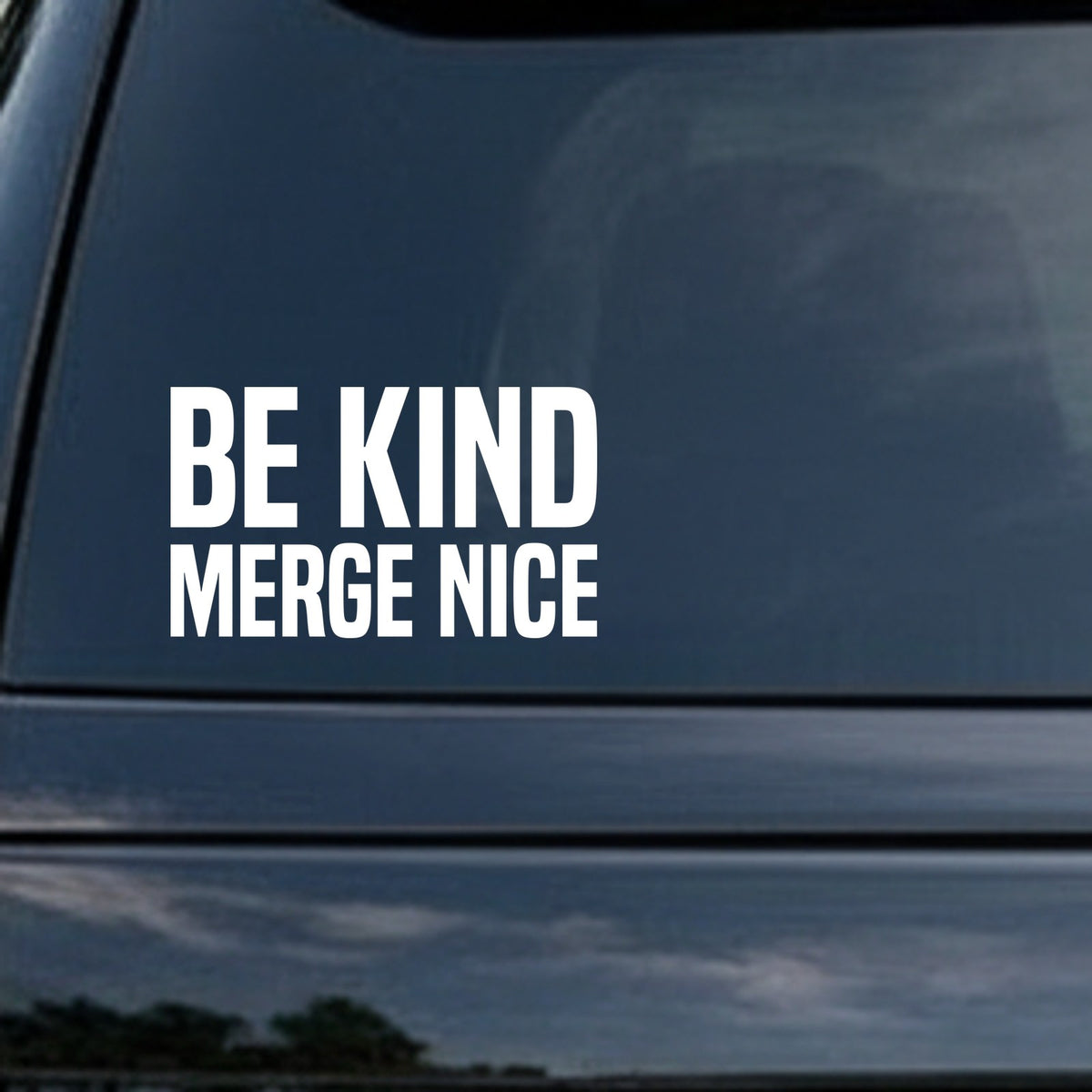 Black and white vinyl decal showing the phrase 'Be Kind Merge Nice' in large block letters on a plain background.