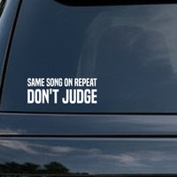 Bold white text on black background saying Same Song On Repeat Don't Judge in all capital letters for a vinyl decal