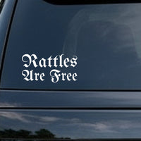 White gothic Old English lettering spelling out 'Rattles Are Free' on a black background in a vinyl decal style.