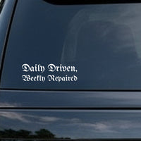 Vinyl decal with white gothic Old English lettering saying Daily Driven, Weekly Repaired on black background