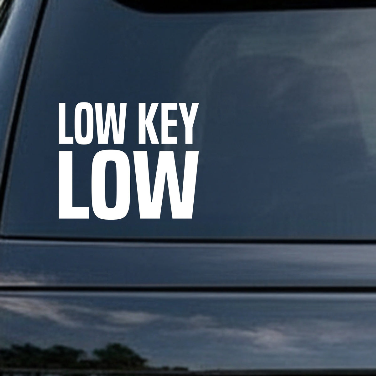 Bold white vinyl decal with the phrase 'Low Key Low' in large uppercase letters on a black background.