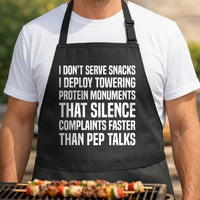 Black apron with large white bold text reading a humorous quote about serving towering protein monuments to silence complaints.