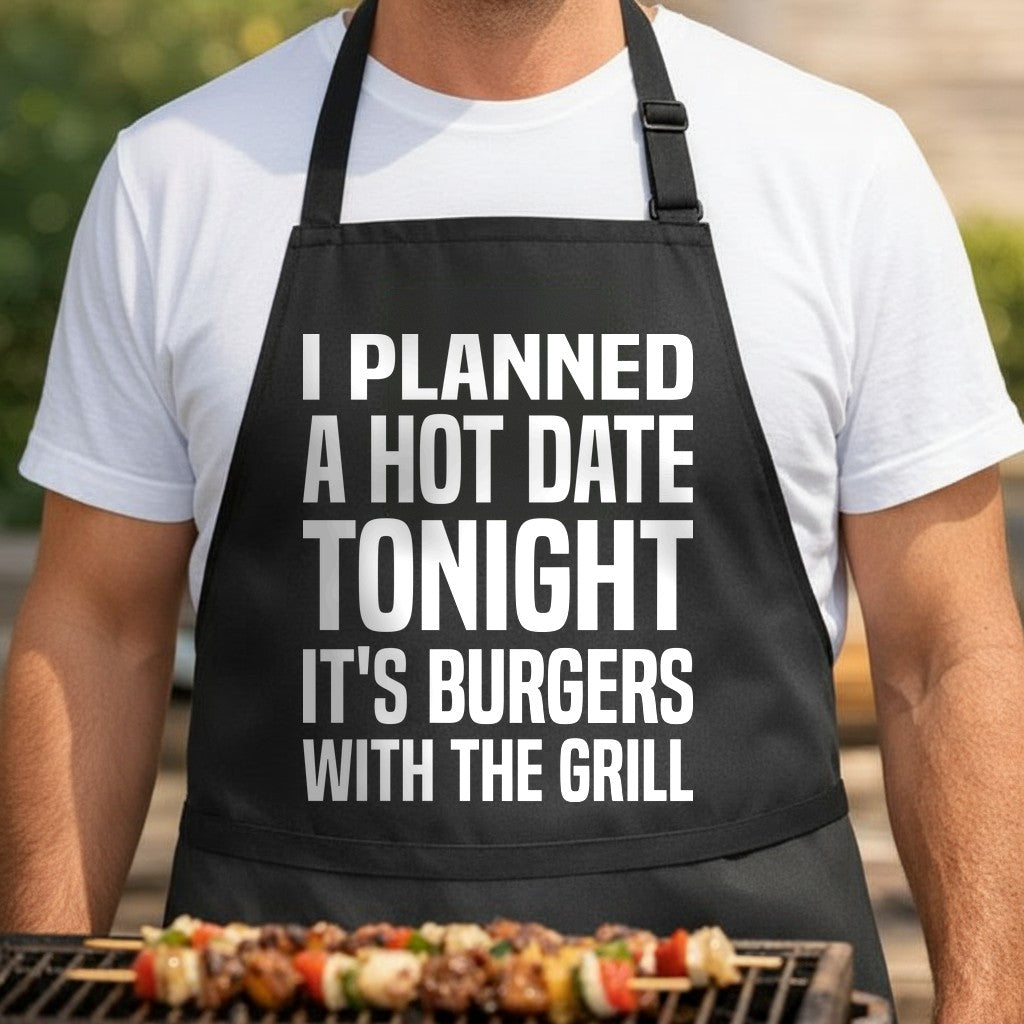 Black apron with bold white text saying Planned A Hot Date Tonight It's Burgers With The Grill in large block letters