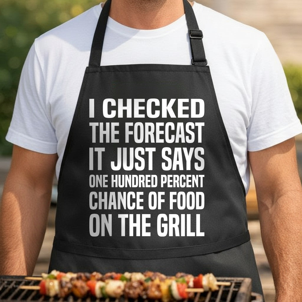Black apron with large white text reading a humorous weather forecast predicting a 100 percent chance of food on the grill in bold, block letters.