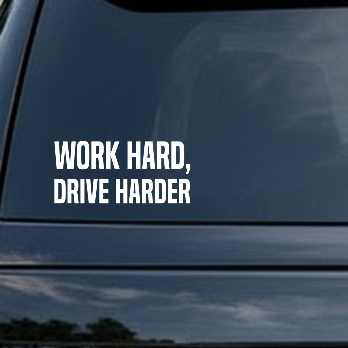White vinyl decal with the phrase Work Hard, Drive Harder in bold block letters on a black background