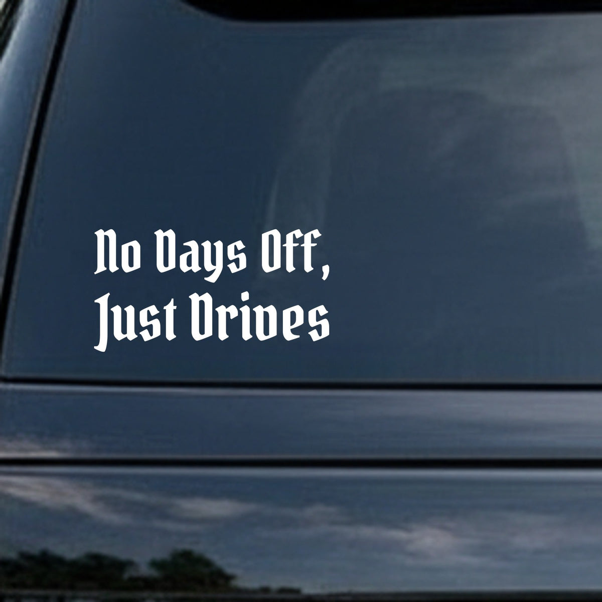 White gothic blackletter text saying No Days Off, Just Drives on a black background in Old English style font