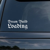 White gothic blackletter text saying Dream Build Loading on a solid black background in old English style lettering.