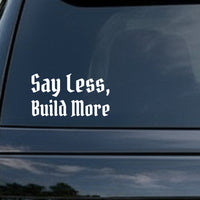 White vinyl decal with gothic blackletter font saying Say Less, Build More on a solid black background.