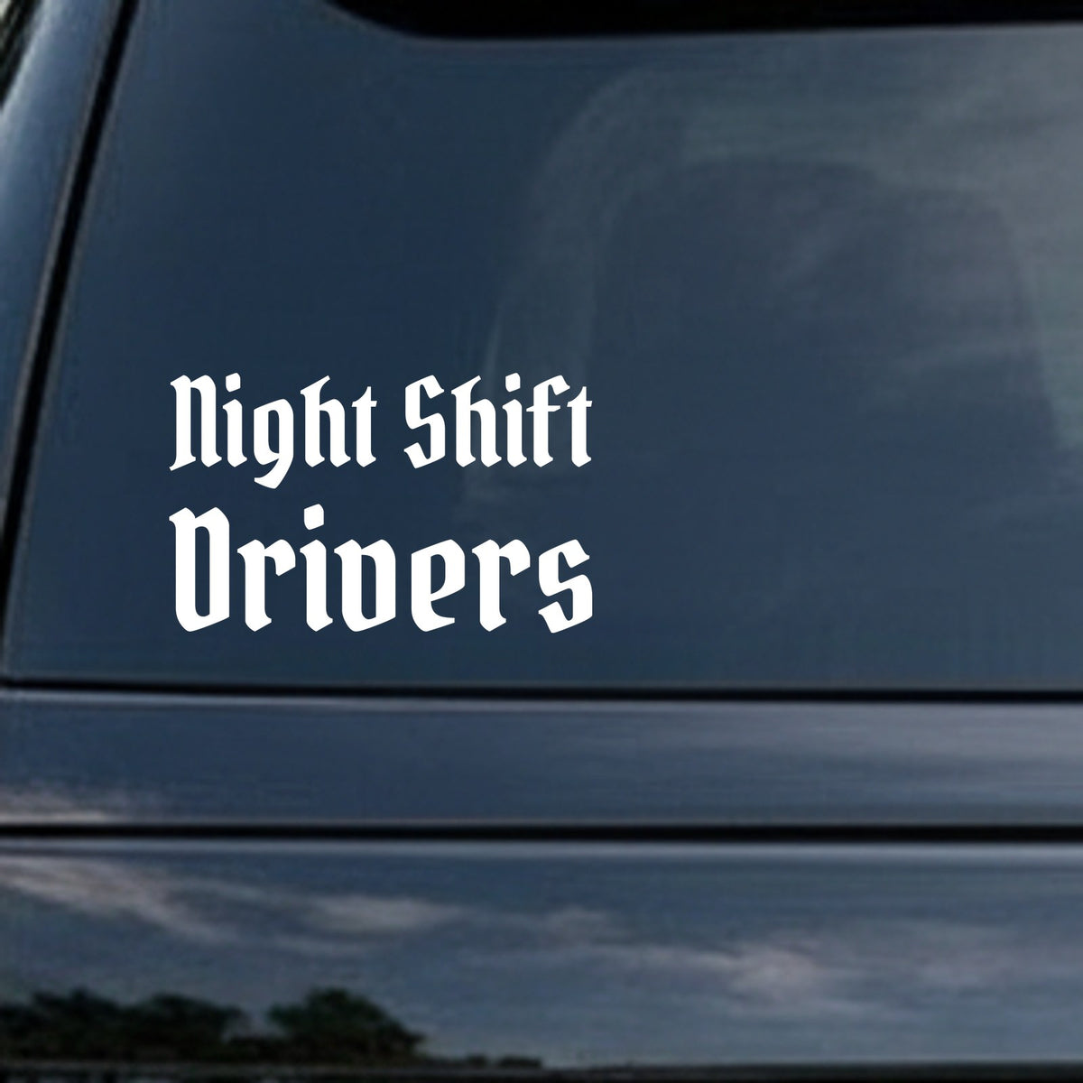 White gothic blackletter Old English font text saying Night Shift Drivers on a black background