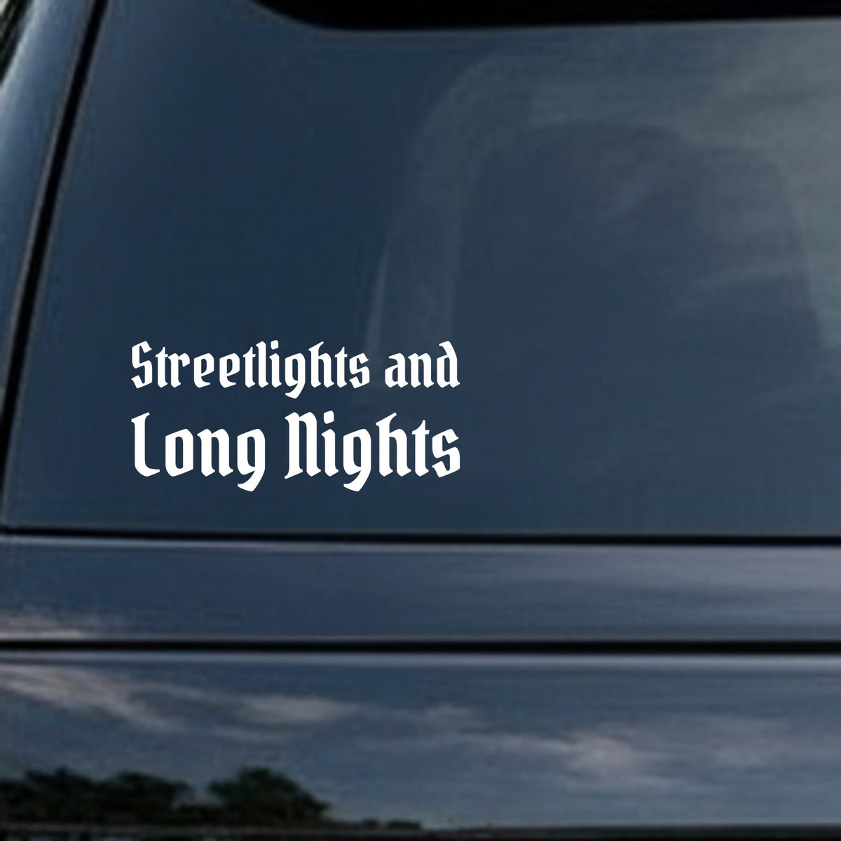 White gothic blackletter text saying Streetlights and Long Nights on a black background in Old English style font.