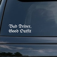 White gothic blackletter text saying 'Bad Driver, Good Outfit' on a black background in Old English style font.
