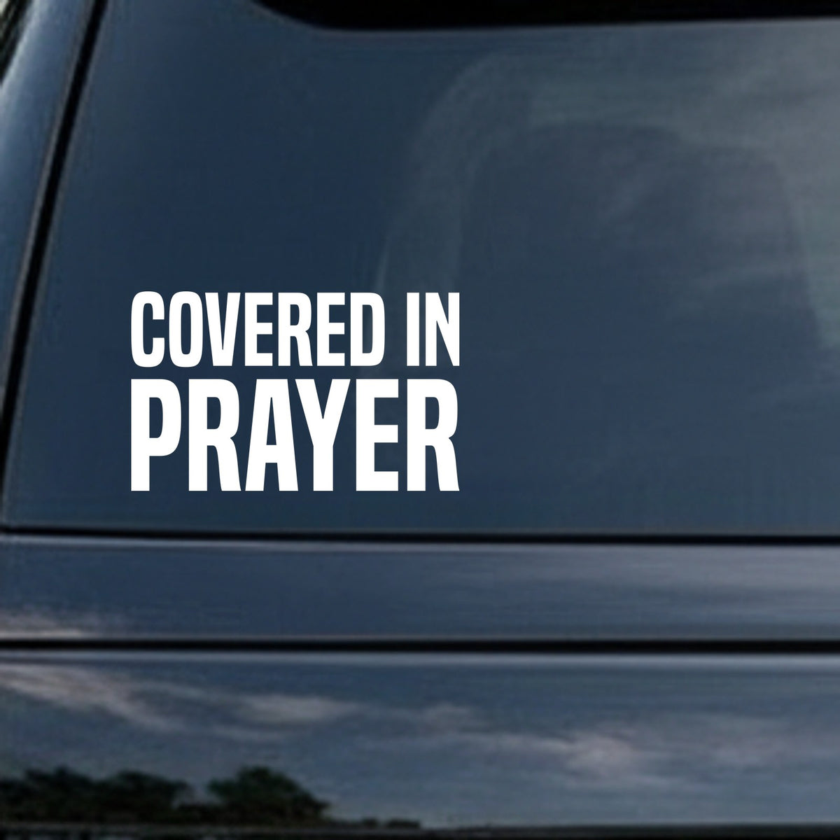 White bold capital letters spelling Covered in Prayer on a black background in a clean sans-serif font.