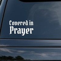 Vinyl decal with the words 'Covered in Prayer' in white gothic blackletter font on a black background.