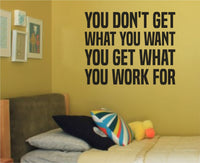 Black vinyl wall decal with the quote 'You Don't Get What You Want, You Get What You Work For' in bold uppercase letters on white background