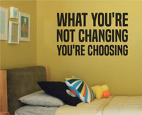 Black vinyl wall decal with the motivational quote What You're Not Changing You're Choosing in bold block letters on a white background.