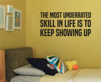 Black vinyl wall decal with the motivational quote The Most Underrated Skill In Life Is To Keep Showing Up in bold uppercase text on transparent background