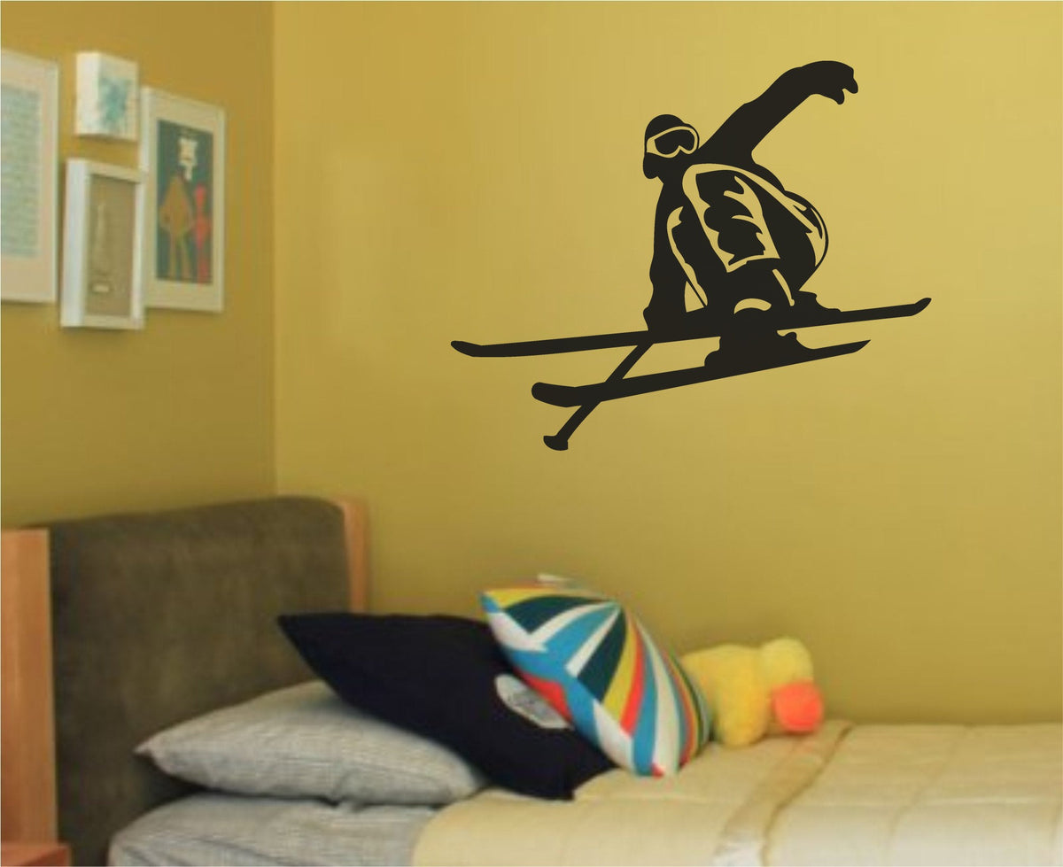 Black silhouette of a ski jumper airborne with bent knees and outstretched arm, wearing goggles and winter gear