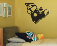 Black and white silhouette of a high top sneaker with laces and a circular patch in a bold vinyl wall decal style