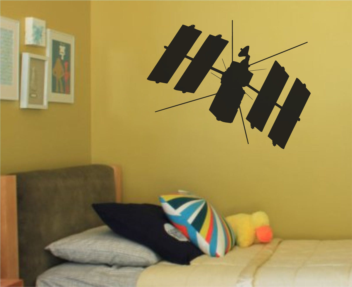 Black silhouette of a space station with solar panels and antennas against a white background in a simple graphic style.
