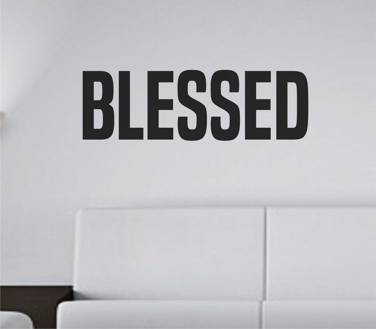 Bold black tall block lettering spelling the word Blessed on a white background in a simple vinyl wall decal style