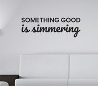 Black vinyl wall decal with the quote 'Something Good Is Simmering' in clean, modern script on a white background.