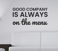Black vinyl wall decal with the quote Good Company Is Always On The Menu in a clean, bold font on a white background.