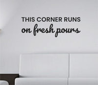 Black vinyl wall decal with the phrase This corner runs on fresh pours in clean, modern typography on a white background.
