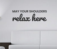 Black vinyl wall decal with the quote 'May your shoulders relax here.' on a white background in simple modern lettering.