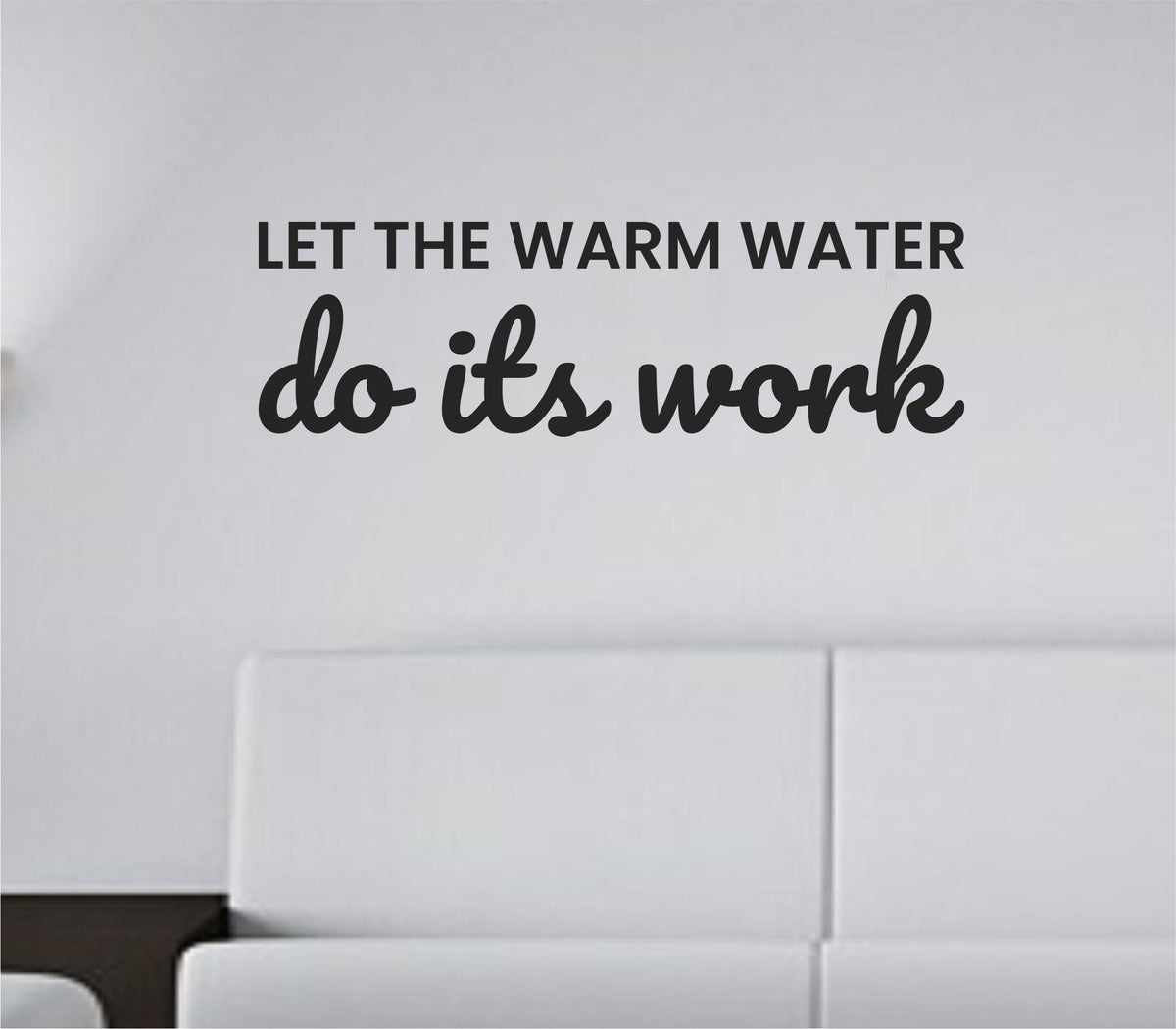 Black vinyl wall decal with the phrase Let the warm water do its work in a clean, simple font on a white background.
