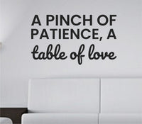 Black vinyl wall decal with the quote 'A pinch of patience, a table of love.' in simple handwritten style on white background.