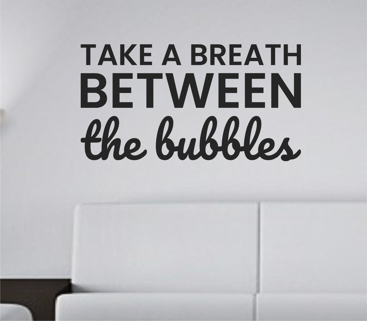 Black vinyl wall decal with the quote 'Take a breath between the bubbles.' in simple, modern lettering on white background.