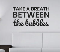 Black vinyl wall decal with the quote 'Take a breath between the bubbles.' in simple, modern lettering on white background.