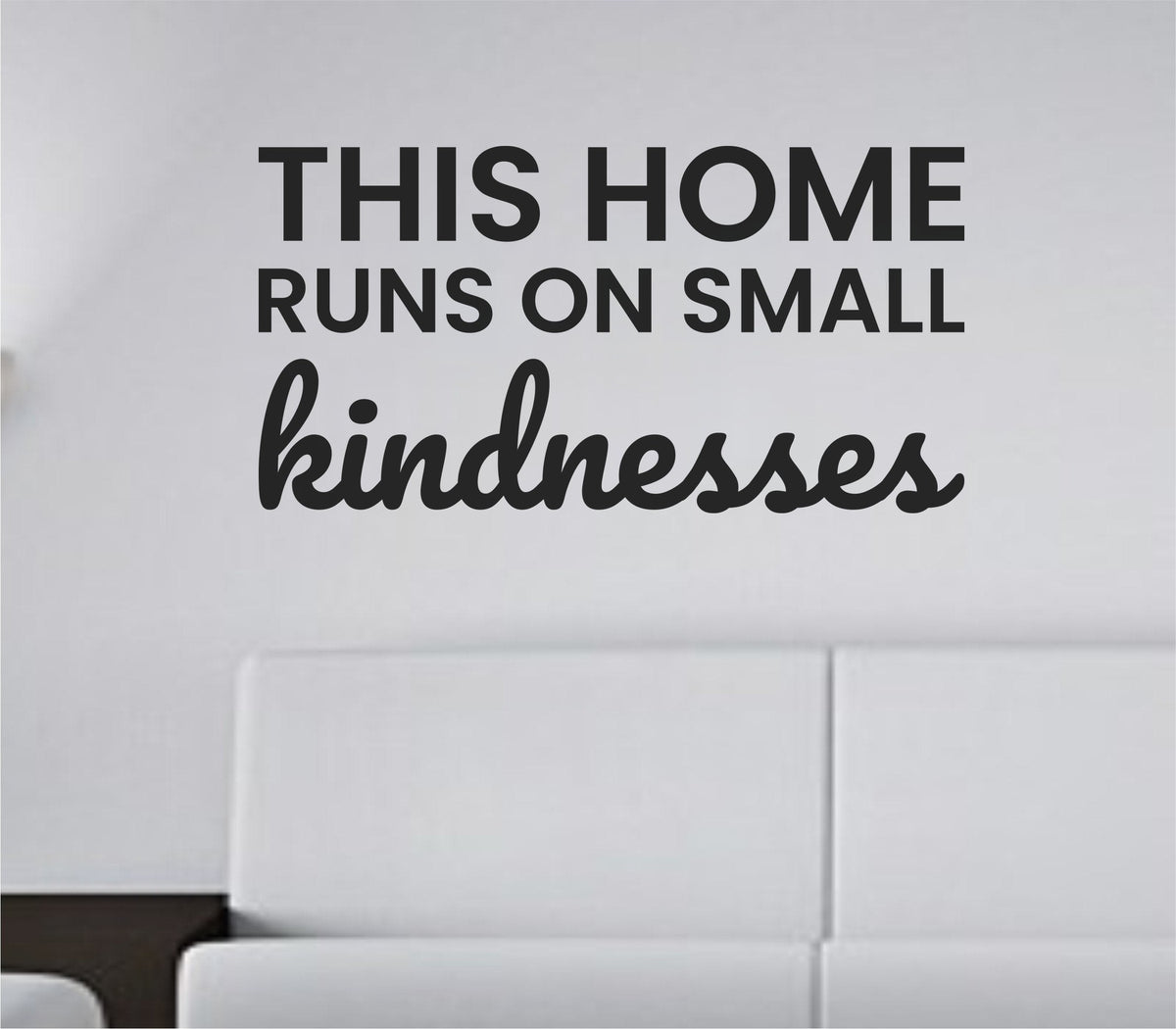Black vinyl wall decal quote reading "This home runs on small kindnesses" on white background in simple elegant font
