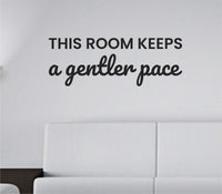 Black vinyl wall decal with the quote This room keeps a gentler pace in a simple, modern font on a white background.
