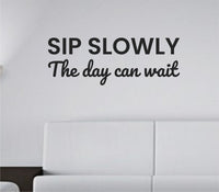 Black vinyl wall decal reading 'Sip slowly. The day can wait.' in simple script on white background