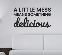 Black vinyl wall decal with the quote 'A Little Mess Means Something Delicious' in simple, modern script on a white background.