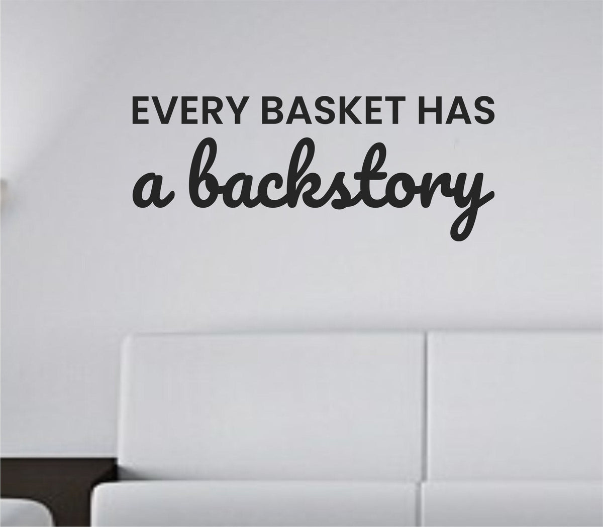 Black vinyl wall decal with the quote 'Every basket has a backstory.' in clean modern lettering on white background