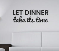 Black vinyl wall decal with the phrase Let dinner take its time in a casual script font on a white background.