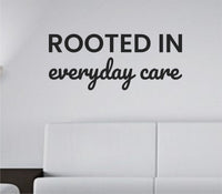 Black one-color vinyl wall decal with the quote 'Rooted in everyday care.' in simple, modern typography on white background.