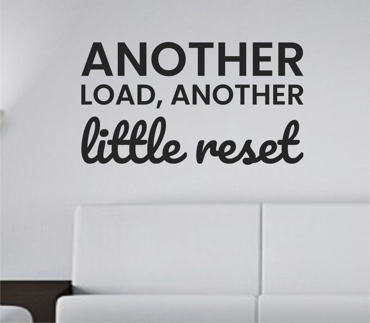Black vinyl wall decal with the phrase 'Another load, another little reset.' in simple modern font on a white background.
