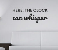Black vinyl wall decal with the phrase Here, the clock can whisper in simple, calm typography on a white background.
