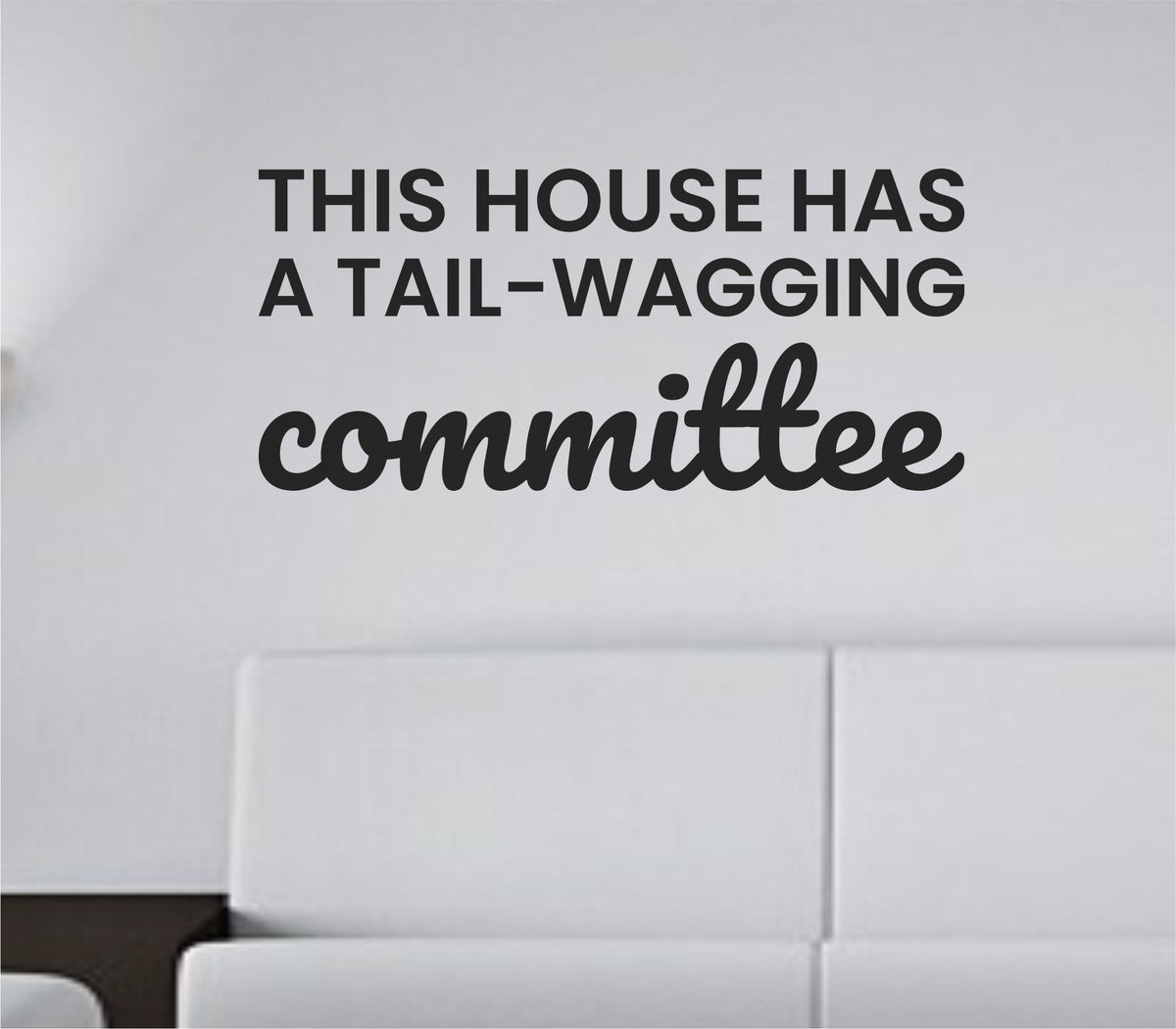 Black vinyl wall decal displaying the text 'This house has a tail-wagging committee' in playful, bold font on a white background.