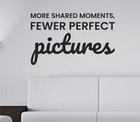 Black vinyl wall decal with the quote More shared moments fewer perfect pictures in a clean, modern font on a white background.