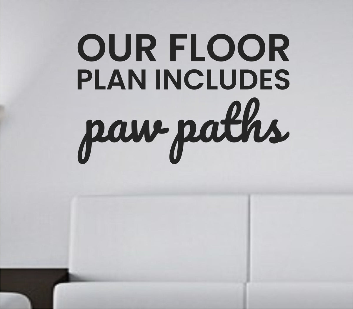 Black vinyl wall decal with the quote 'Our floor plan includes paw paths' in playful script on white background