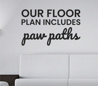 Black vinyl wall decal with the quote 'Our floor plan includes paw paths' in playful script on white background