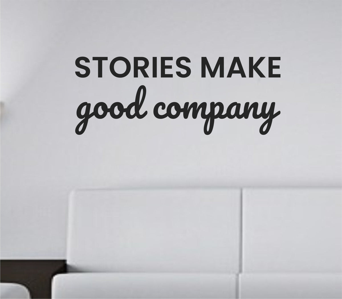 Black vinyl wall decal quote saying “Stories make good company.” on a plain white background in simple serif font.