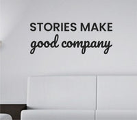 Black vinyl wall decal quote saying “Stories make good company.” on a plain white background in simple serif font.