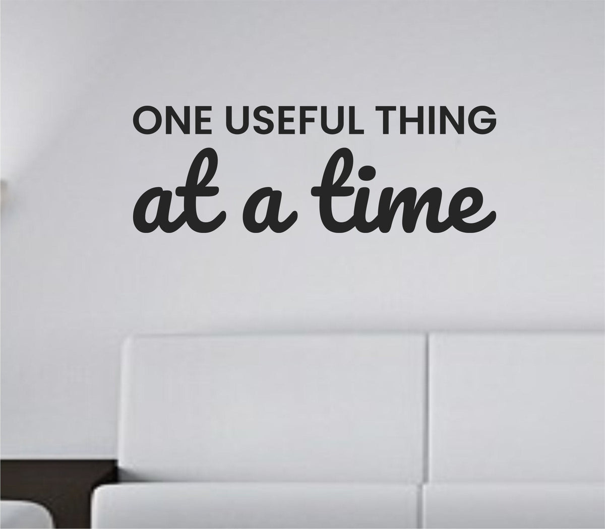 Black vinyl wall decal with the text 'One useful thing at a time.' in simple, modern font on a white background.