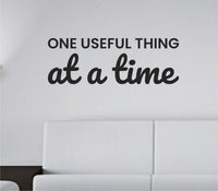 Black vinyl wall decal with the text 'One useful thing at a time.' in simple, modern font on a white background.