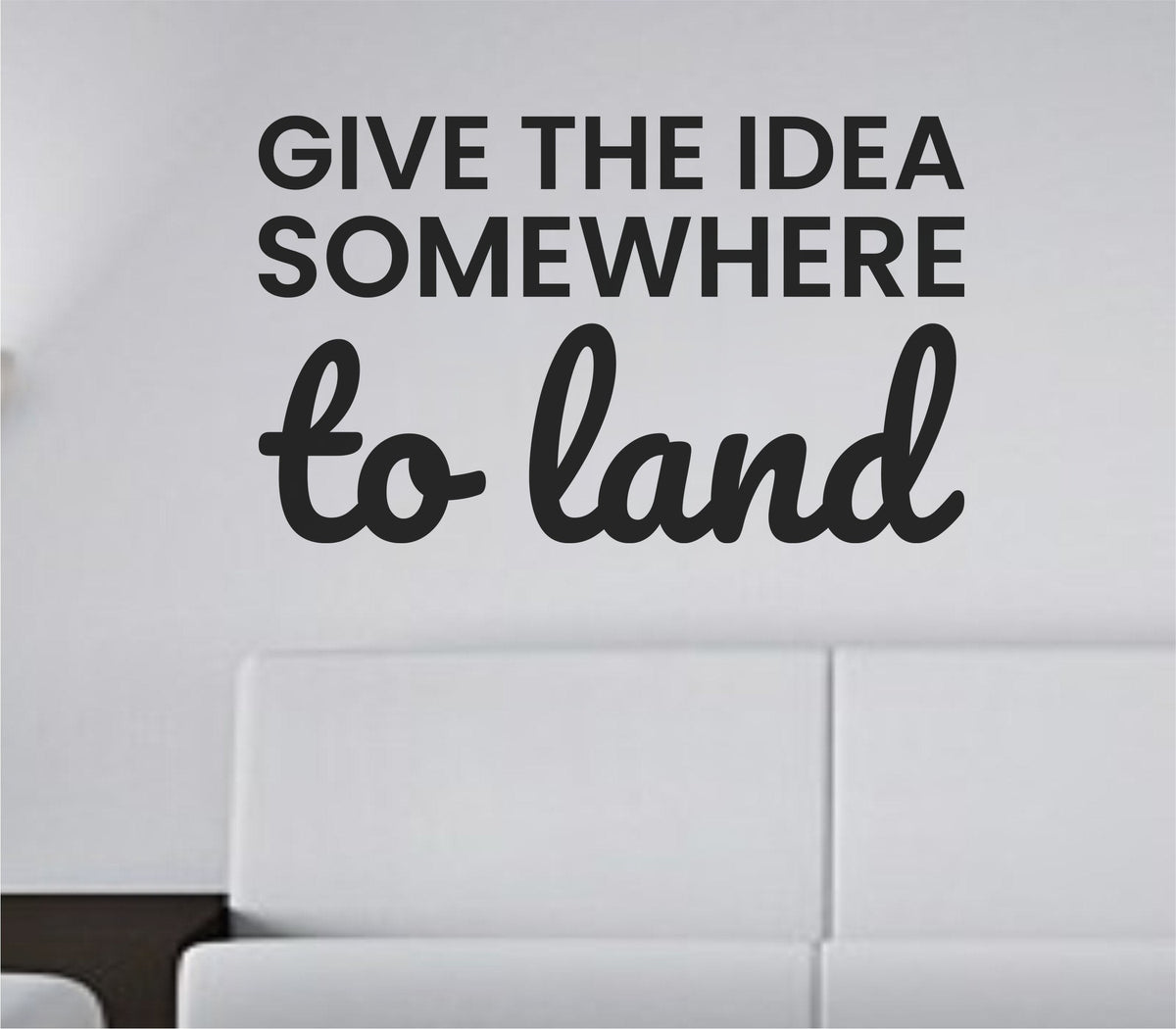 Black vinyl wall decal with the quote 'Give the idea somewhere to land' in elegant script font on a white background.